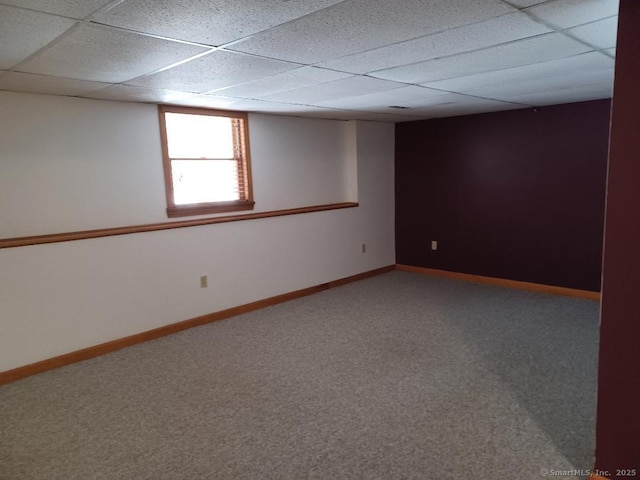 carpeted empty room featuring a drop ceiling