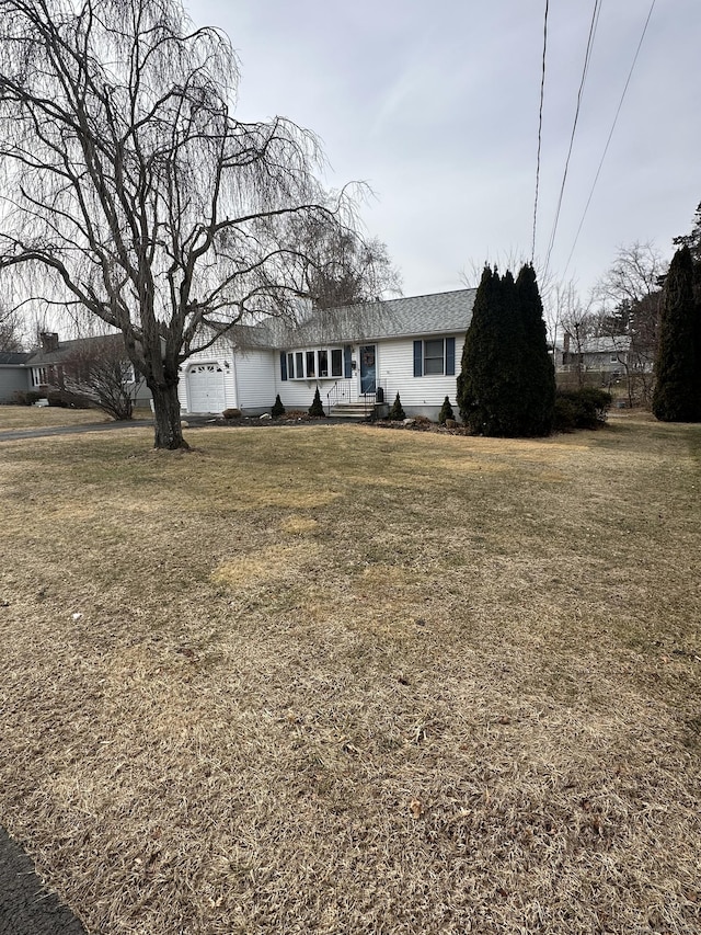 view of front of property featuring a garage and a front yard