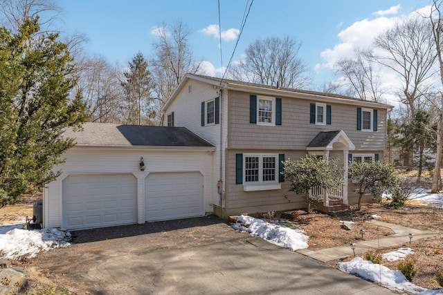 colonial home featuring a garage and aphalt driveway