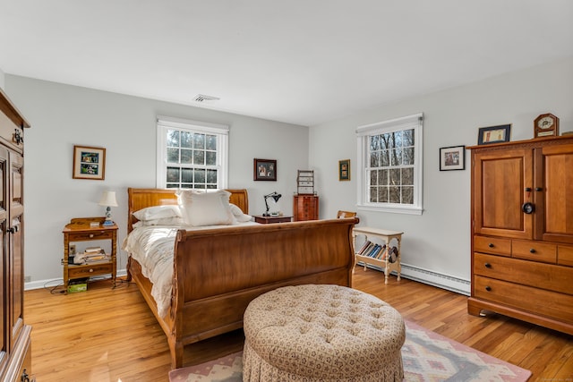 bedroom featuring a baseboard radiator, visible vents, light wood-style flooring, and baseboards