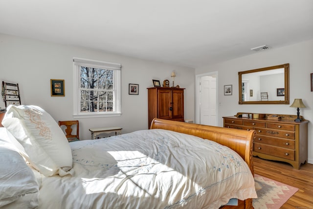 bedroom with visible vents and wood finished floors