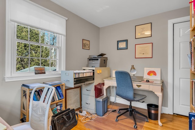 home office with baseboards and wood finished floors