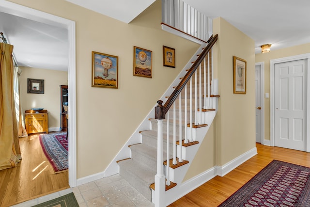 stairs featuring wood finished floors and baseboards