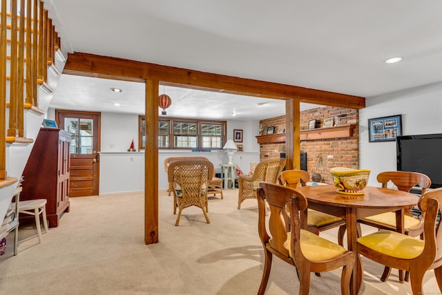 dining space featuring light carpet, plenty of natural light, a fireplace, and stairs