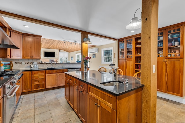 kitchen with decorative backsplash, appliances with stainless steel finishes, brown cabinets, a sink, and a wall mounted AC