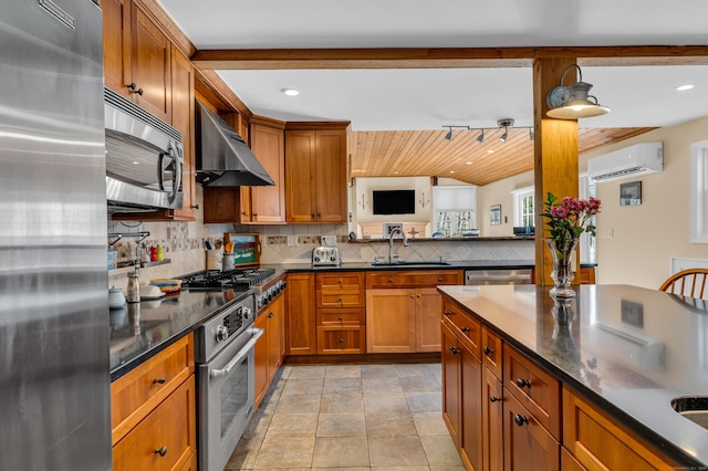 kitchen with stainless steel appliances, an AC wall unit, brown cabinetry, and wall chimney exhaust hood