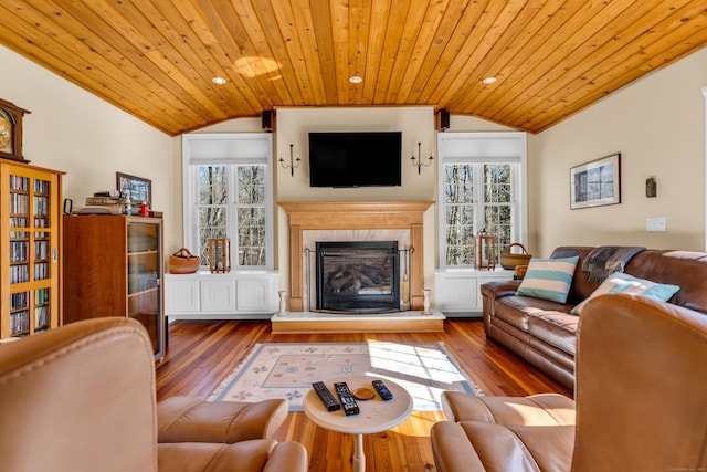 living area featuring vaulted ceiling, wooden ceiling, and a healthy amount of sunlight