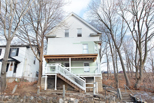 rear view of property featuring covered porch