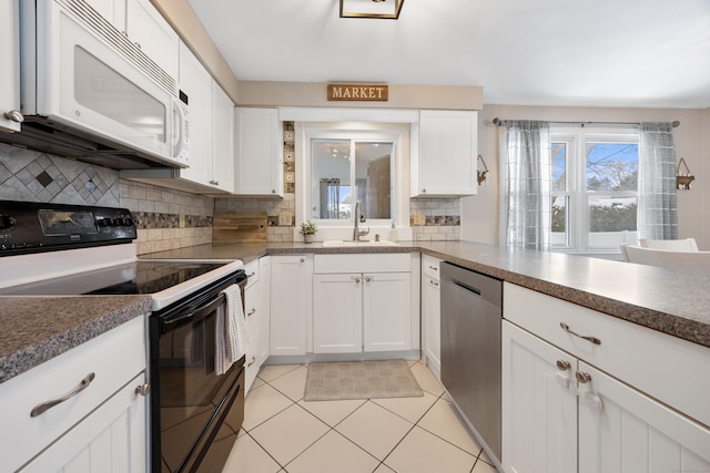 kitchen with sink, white cabinetry, light tile patterned floors, range with electric stovetop, and stainless steel dishwasher