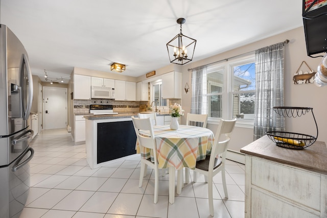 kitchen featuring light tile patterned flooring, white cabinetry, decorative backsplash, hanging light fixtures, and stainless steel refrigerator with ice dispenser