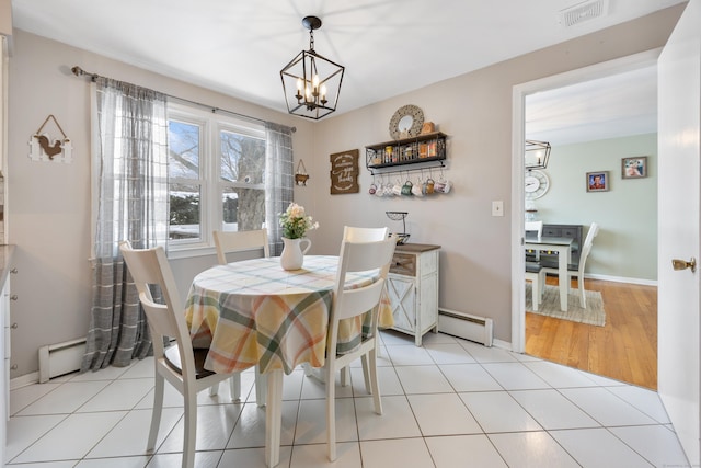 tiled dining room with an inviting chandelier and baseboard heating