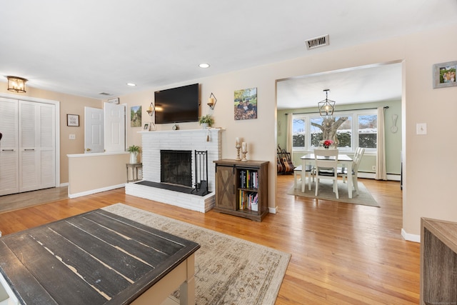 living room featuring a brick fireplace and hardwood / wood-style floors