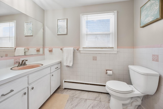 bathroom with vanity, a baseboard heating unit, tile walls, and toilet