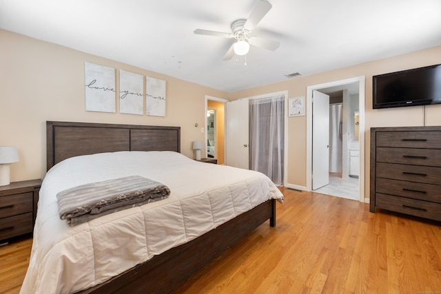 bedroom featuring ceiling fan, ensuite bathroom, and light hardwood / wood-style flooring