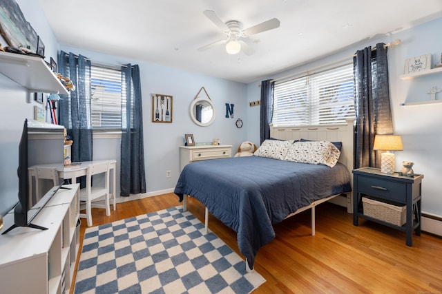 bedroom featuring multiple windows, light hardwood / wood-style floors, and ceiling fan