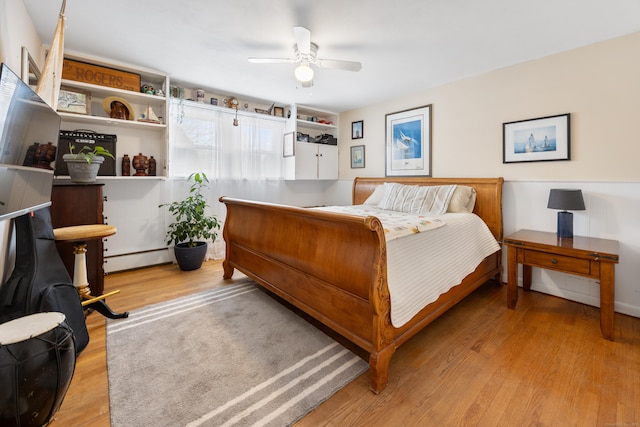 bedroom with ceiling fan, a baseboard radiator, and light wood-type flooring