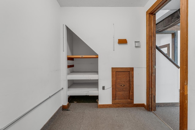 corridor featuring baseboards and carpet floors