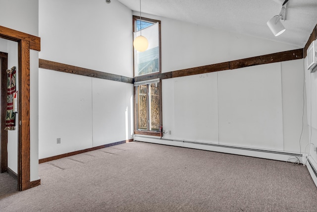 carpeted empty room with track lighting, a textured ceiling, high vaulted ceiling, and a baseboard heating unit