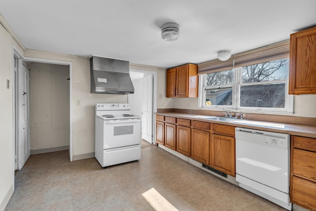 kitchen with a sink, white appliances, wall chimney exhaust hood, brown cabinetry, and light countertops