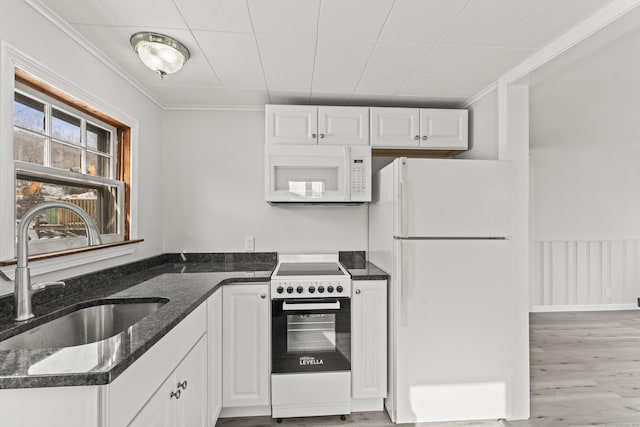 kitchen with sink, white cabinets, white appliances, and dark stone counters