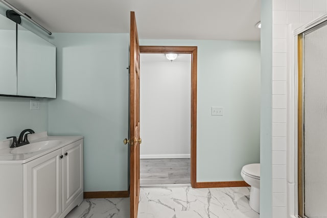 bathroom featuring vanity, toilet, and an enclosed shower