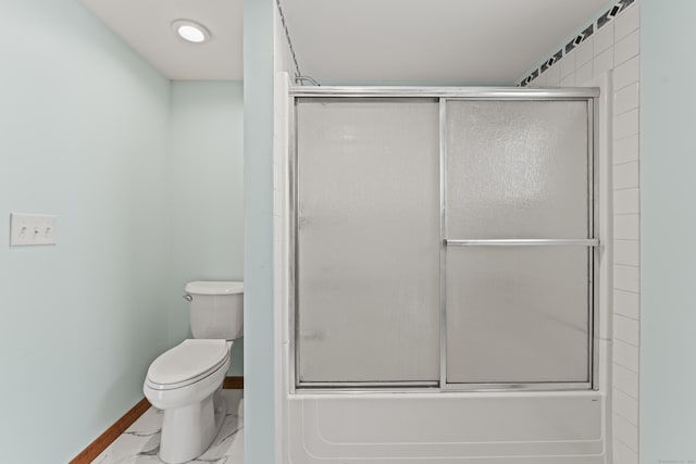 bathroom featuring combined bath / shower with glass door and toilet