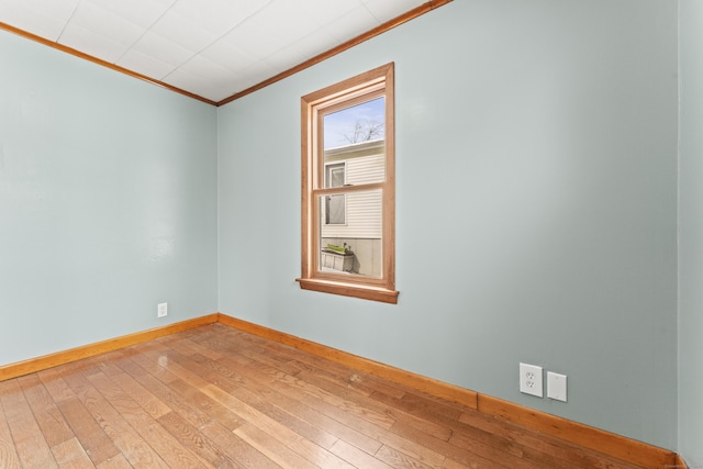 spare room with crown molding and wood-type flooring