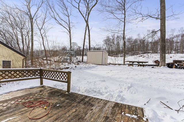 snow covered deck featuring a shed