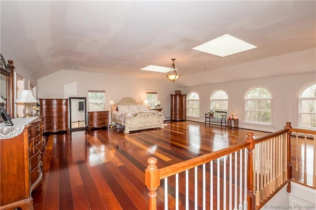 bedroom with dark wood-type flooring and lofted ceiling with skylight