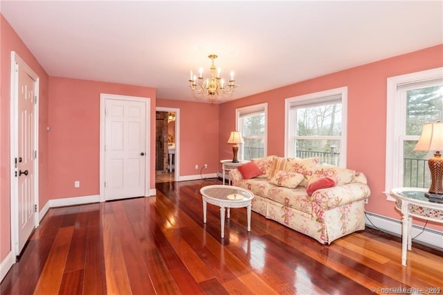 living room featuring hardwood / wood-style floors, a notable chandelier, and baseboard heating