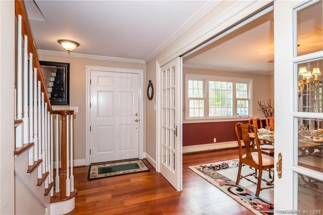 entryway with a baseboard radiator, wood-type flooring, ornamental molding, and french doors