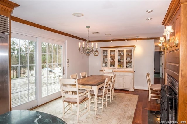 dining space with an inviting chandelier, crown molding, and light hardwood / wood-style floors