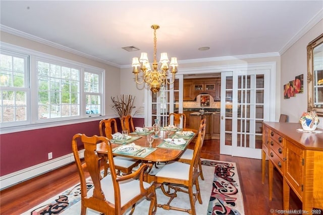 dining area with crown molding, dark hardwood / wood-style floors, a notable chandelier, and baseboard heating