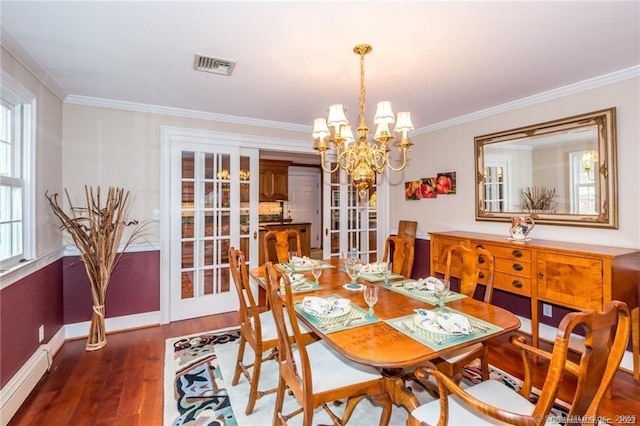 dining space with crown molding, a notable chandelier, dark wood-type flooring, and a baseboard radiator