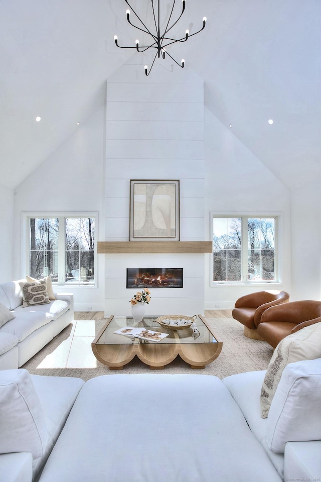 living room featuring a large fireplace, high vaulted ceiling, plenty of natural light, and carpet flooring