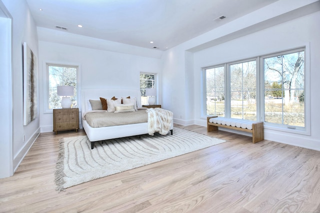 bedroom with baseboards, light wood-style flooring, visible vents, and recessed lighting