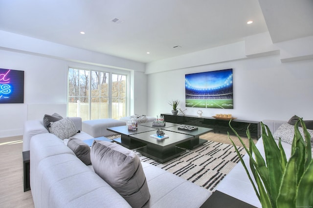 living area featuring light wood-style floors, baseboards, visible vents, and recessed lighting