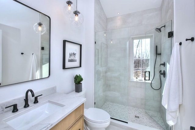 bathroom featuring toilet, a tile shower, and vanity