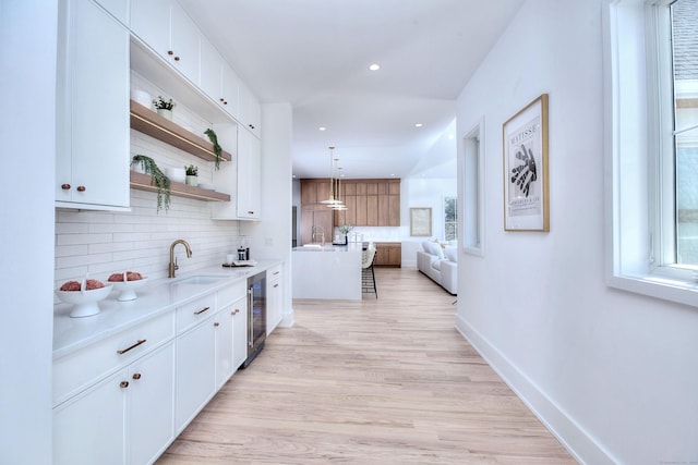 kitchen with a kitchen island, white cabinetry, pendant lighting, and light countertops