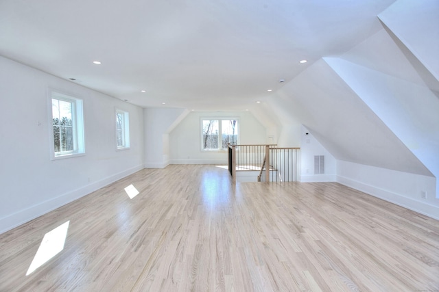 additional living space featuring recessed lighting, lofted ceiling, visible vents, light wood-style floors, and baseboards