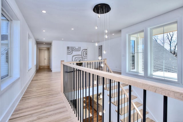 hall with light wood finished floors, recessed lighting, baseboards, and an upstairs landing