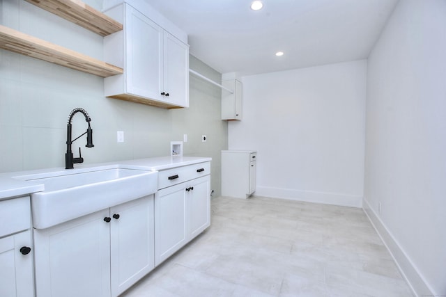 washroom with washer hookup, recessed lighting, cabinet space, a sink, and baseboards