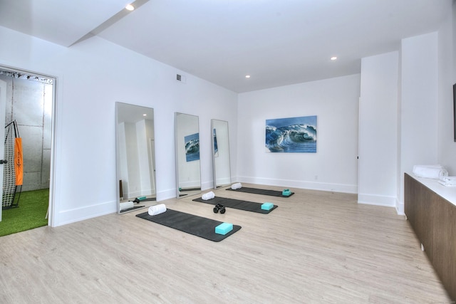 exercise room with recessed lighting, visible vents, light wood-style flooring, and baseboards