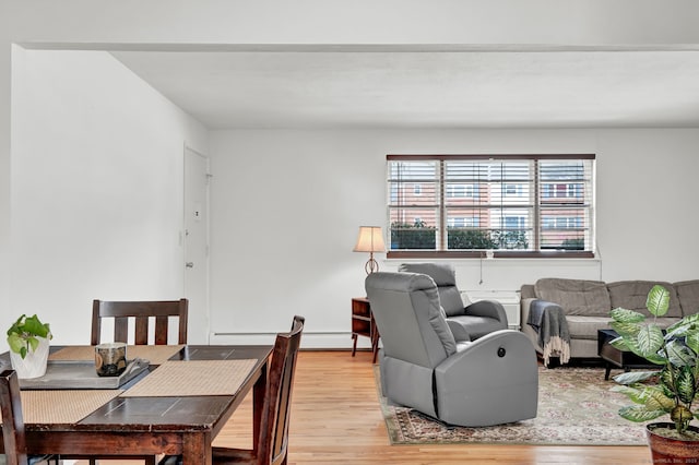 living room with baseboard heating and light hardwood / wood-style flooring