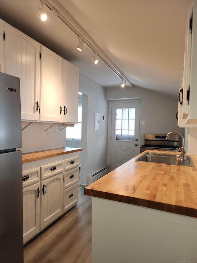kitchen with freestanding refrigerator, a sink, and butcher block counters