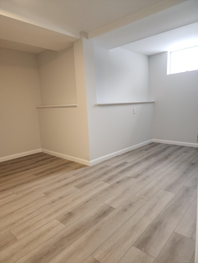 below grade area with baseboards and wood finished floors