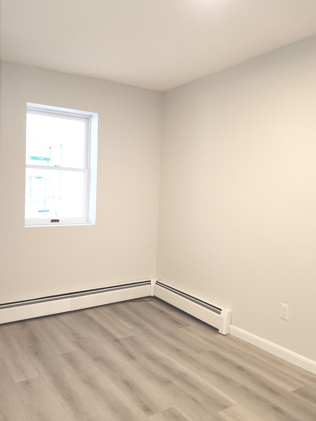 unfurnished room with baseboards and wood finished floors