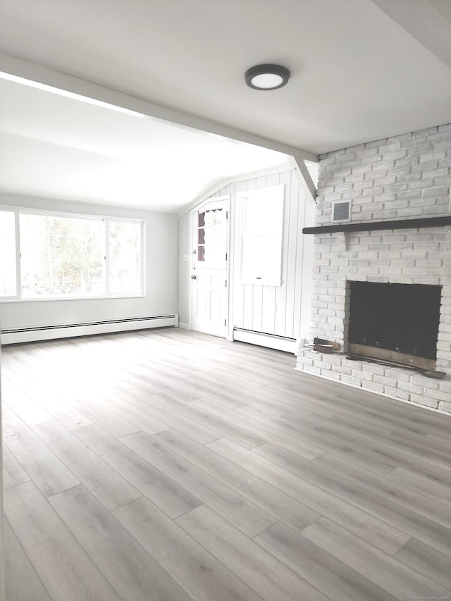 unfurnished living room featuring vaulted ceiling, a baseboard heating unit, wood finished floors, and visible vents
