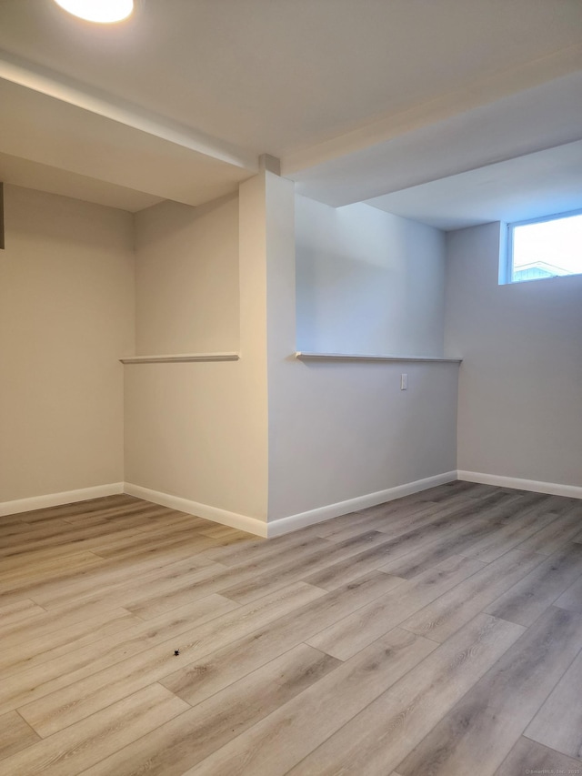 below grade area featuring baseboards and wood finished floors