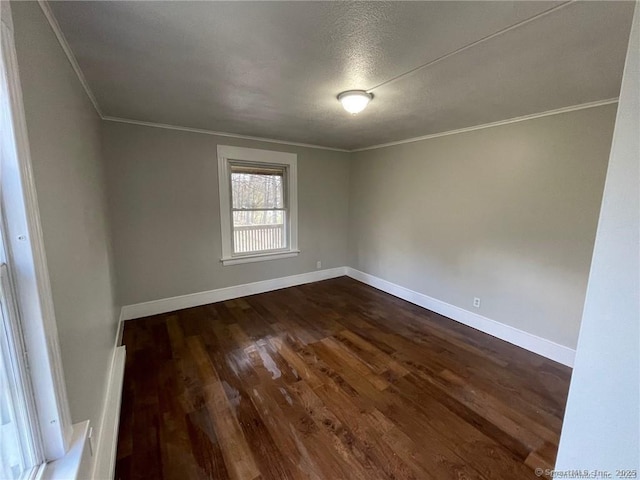 empty room featuring ornamental molding and dark hardwood / wood-style floors